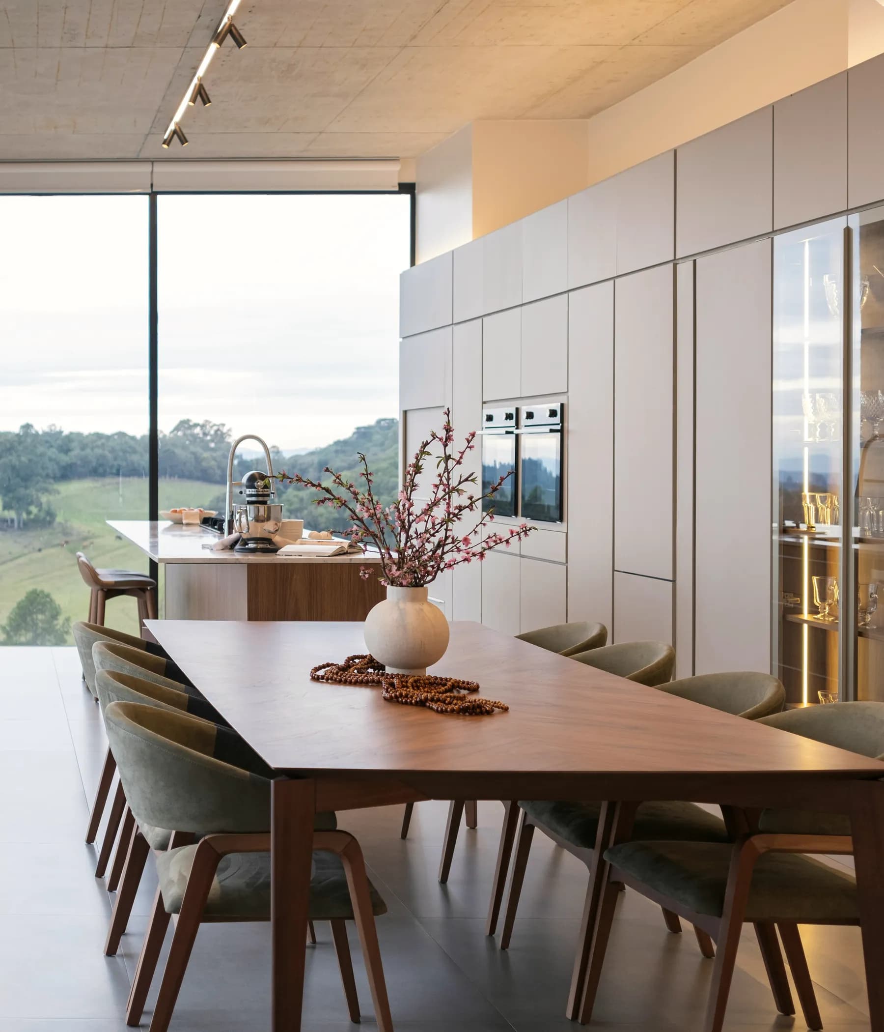 Sala de jantar contemporânea com madeira, luz natural e vista exterior